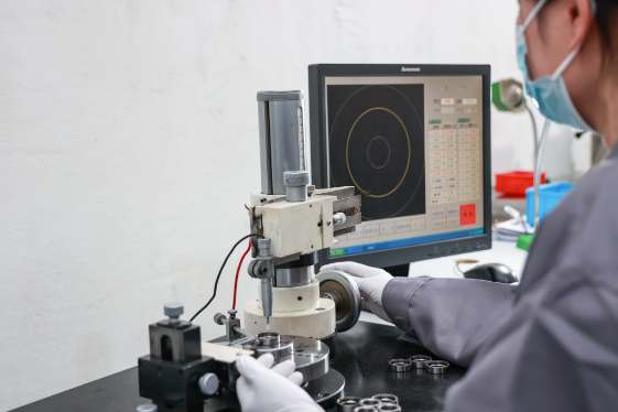 Technician performing quality control inspection on bearing components