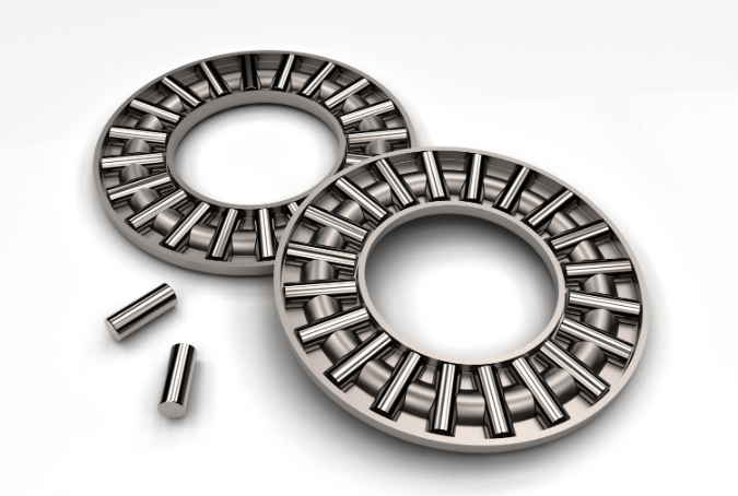 Two thrust cylindrical roller bearing cage assemblies with three individual cylindrical rollers shown separately on a white background.